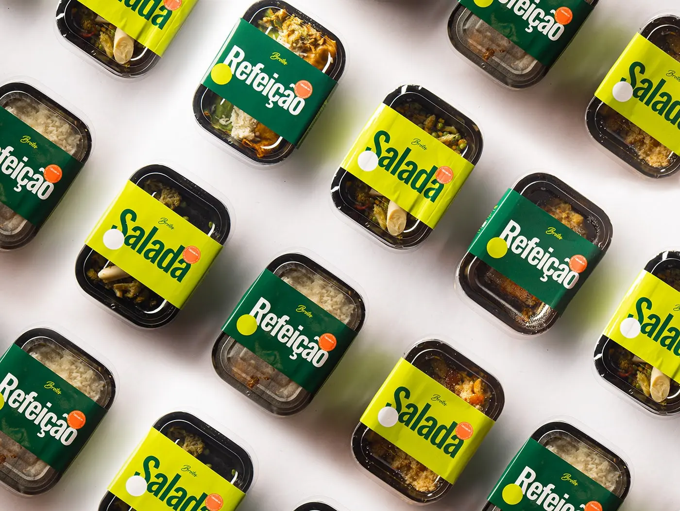Primary Packaging Shot: "A vibrant packaging of Brotos Salad showcasing a rich green background adorned with lively pop colors illustrating the fresh and healthy ingredients contained within.