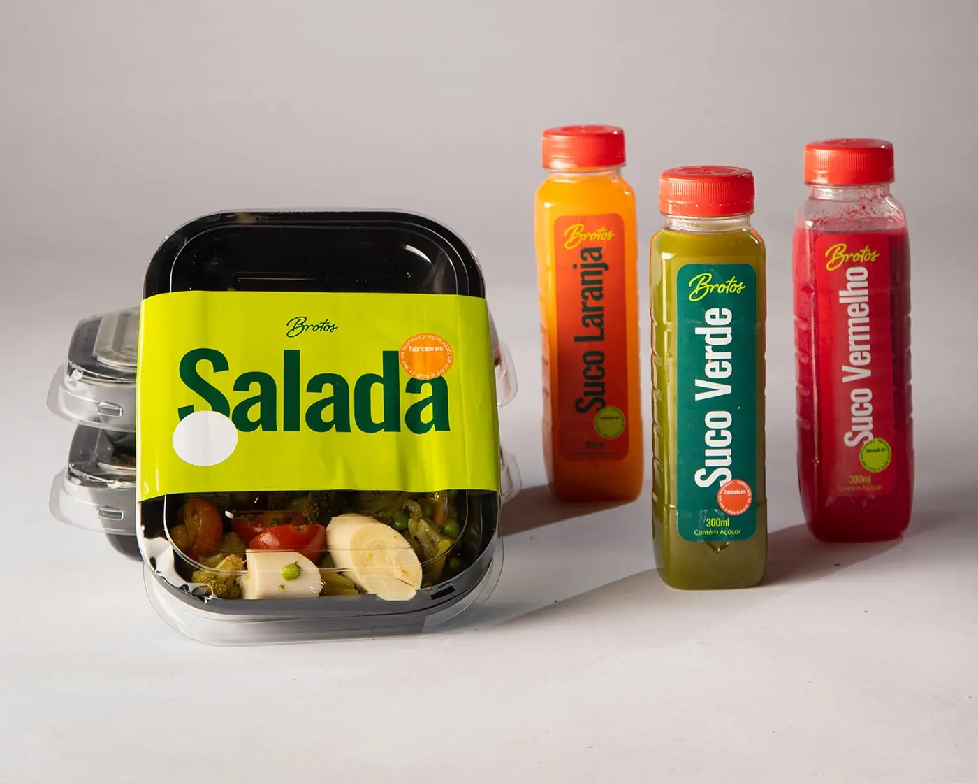 Primary Packaging Shot: "A vibrant packaging of Brotos Salad showcasing a rich green background adorned with lively pop colors illustrating the fresh and healthy ingredients contained within.